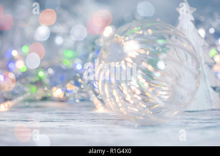 Weihnachten dekoratives Glas Kugel und glühenden verschwommen Lichtgirlanden auf glitzerndem Silber Hintergrund Stockfoto