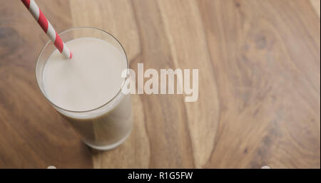 Hafermilch in Glas mit rotem Papier Stroh auf Holz Hintergrund mit Kopie Raum, große Foto Stockfoto