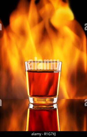 Whiskey in kleinen shot Glas und Feuer Stockfoto