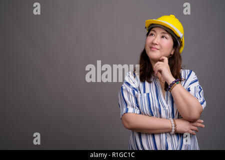 Reifen asiatischen Geschäftsfrau Bauarbeiter tragen, hardhat Stockfoto