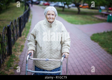Attraktive ältere Frau mit Walker im Freien Stockfoto