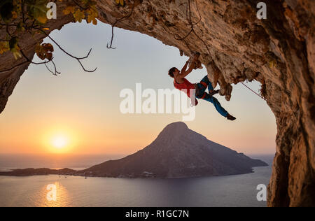 Männliche Kletterer auf anspruchsvolle Strecke auf einer Klippe bei Sonnenuntergang der Insel Kalymnos, Griechenland Stockfoto
