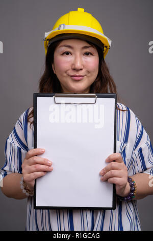 Reifen asiatischen Geschäftsfrau Bauarbeiter tragen, hardhat Stockfoto