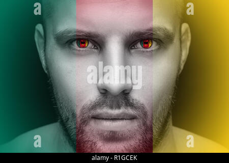 Portrait einer jungen ernster Mann, in dessen Augen die reflektierte Nationalflagge von Kamerun, gegen einen isolierten schwarzen Hintergrund und Flag Stockfoto