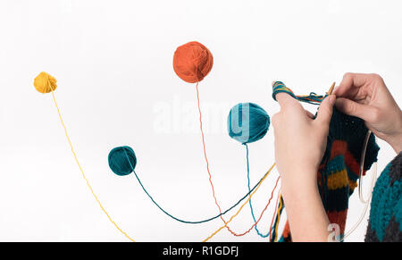 Interessantes Bild mit Garn Kugel in der Luft isoliert auf Weiss. Stricken. Stockfoto