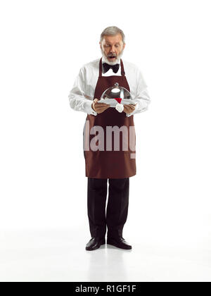 Senior Kellner mit Tablett mit Weihnachtsmütze und stehen auf weißen studio Hintergrund isoliert. Konzept des guten Service und Weihnachten, Weihnachtsmann, happy holiday, Stockfoto