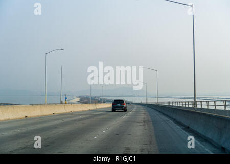 Reisen auf Dumbarton Brücke in Richtung Osten San Francisco Bay Area; Rauch und Verschmutzung der Luft in der Nähe von wildfires, Silicon Valley, Kalifornien Stockfoto