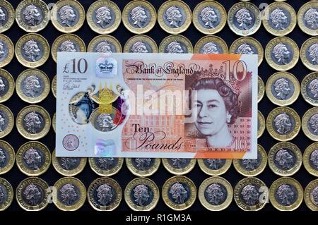 Das neue Polymer £ 10 Hinweis mit Jane Austen, mit der neuen £ 1 Münzen im Hintergrund Stockfoto