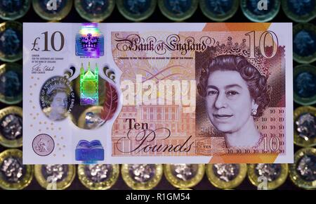 Das neue Polymer £ 10 Hinweis mit Jane Austen, mit der neuen £ 1 Münzen im Hintergrund Stockfoto