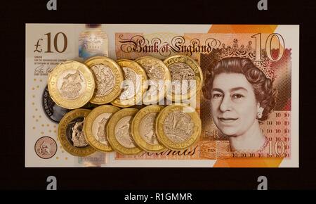 Das neue Polymer £ 10 Hinweis mit Jane Austen, mit der neuen £ 1 Münzen im Hintergrund Stockfoto