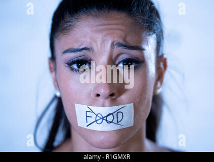 Nahaufnahme, Porträt der jungen attraktiven Latein Frau mit Mund auf Klebeband mit Text keine Lebensmittel in der Ernährung Magersucht Essstörungen Konzept versiegelt. Stockfoto