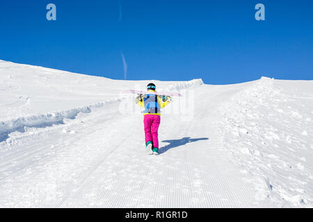 Foto von der Rückseite der weiblichen Athleten mit Snowboard auf den Schultern Stockfoto