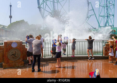 Besucher von einem vorbeifahrenden Wasserrutsche in SeaWorld (Reise nach Atlantis), San Diego, California, United States gespritzt wird. Stockfoto