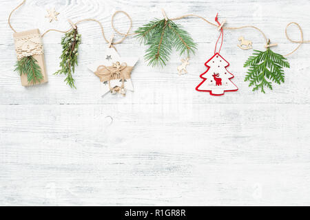 Weihnachtsgirlande aus nadelbaumbaum Branchen & Weihnachtsschmuck gegen weiße Holz- Hintergrund mit kopieren. Stockfoto