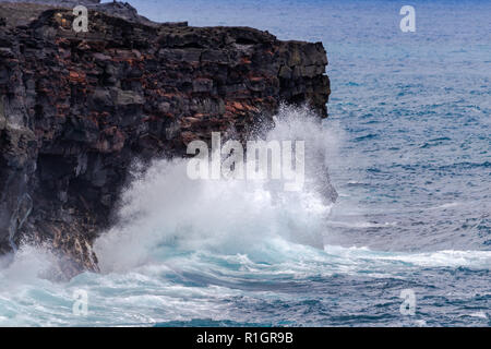 Große Wellen gegen hohen vulkanischen Felsen auf Hawaii Big Island, unten Kraterkette Straße im Volcano National Park. Stockfoto