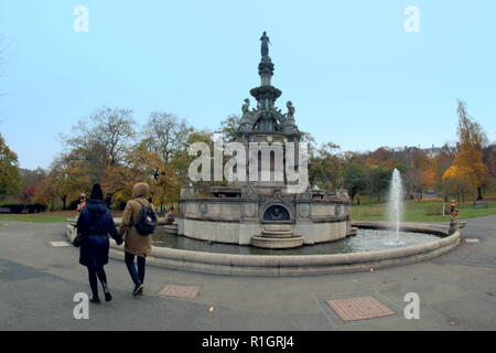 Junges Paar gehen um Stewart Memorial Fountain, Kelvingrove Park, Glasgow, Großbritannien Stockfoto