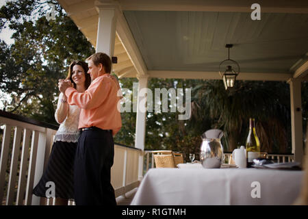 Lächelnd Mitte - erwachsene Paare tanzen zusammen auf einem Balkon. Stockfoto