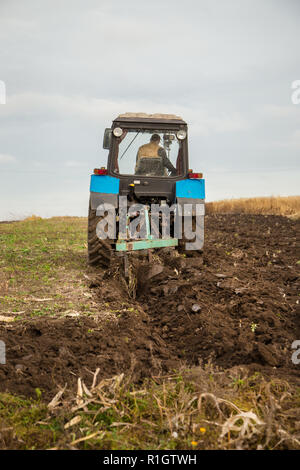 Landwirtschaftliche Arbeiten mit Traktoren, Pflügen im Lande. Herbst Arbeit im Feld. Stockfoto