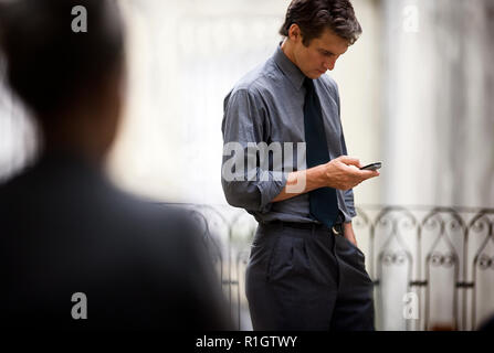 Seitenansicht eines Mannes beschäftigt mit seinem Telefon. Stockfoto