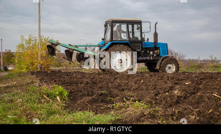 Landwirtschaftliche Arbeiten mit Traktoren, Pflügen im Lande. Herbst Arbeit im Feld. Stockfoto