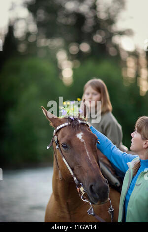 Pferd mit einem halbwüchsigen Mädchen reiten auf ihm. Stockfoto
