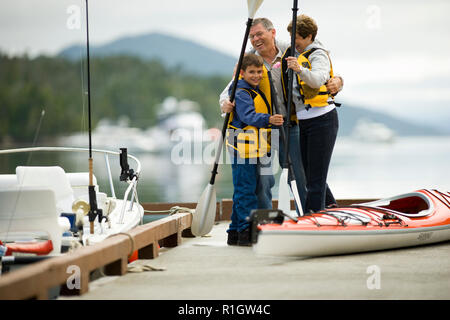 Reifes Paar und ihren jungen Sohn ein Kajak heraus auf einem See. Stockfoto