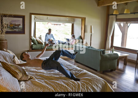 Junge Prellen auf ein Bett in einem Schlafzimmer. Stockfoto