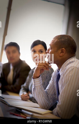 Mitte - Erwachsene Geschäftsmann sitzen mit Kollegen in einem Sitzungssaal. Stockfoto