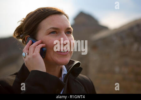 Geschäftsfrau, sprechen über Ihr Handy an der Großen Mauer von China. Stockfoto