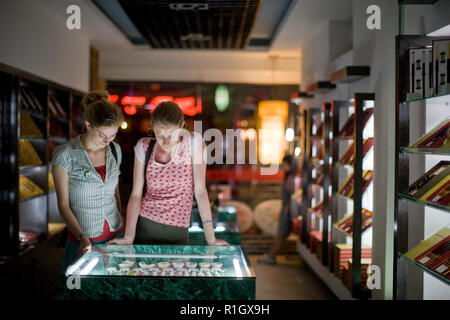 Zwei junge weibliche Touristen auf der Suche nach Schmuck in einem Laden. Stockfoto