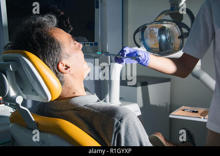 Krankenschwester mit Spritze gibt Injektion eines Patienten in der Zahnarztpraxis. Stockfoto