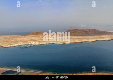 Die kleinen Fischen und touristischen Dorf Caleta del Sebo auf der winzigen Insel La Graciosa neben Lanzarote Kanarischen Inseln. Mount Bermeja ist hinter einer Stockfoto