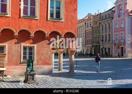 Poznan Marktplatz, Rückansicht einer jungen Frau, die an einem Sommermorgen allein durch den bunten Marktplatz in der Poznan Altstadt geht, Polen. Stockfoto