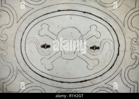 Schädel und Knochen auf einem der Grabsteine, die in der Basilika di Santa Croce (Basilika des Heiligen Kreuzes) in Florenz, Toskana, Italien dargestellt. Stockfoto