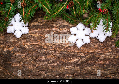 Christmas tree branches mit Schneeflocken Kugeln und Lichtern auf Holz- Hintergrund. Stockfoto