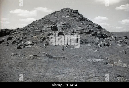 1950, historische, Exmoor National Park, eine Dame steht vor der felsigen Gipfel oder Tor, einer von vielen, die auf dem Moor. Stockfoto