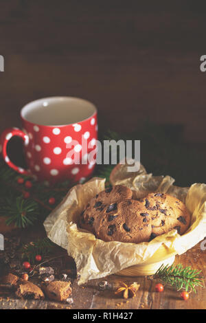 Weihnachten und neues Jahr Komposition mit köstlichen Schokolade Cookies, Erdnüssen und Tasse Kaffee oder Tee, Niederlassungen Fichte und kiefer Kegel auf dunklen Holz- b Stockfoto