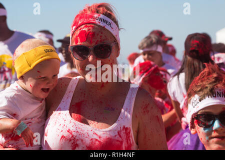 Junge blonde Mutter und Baby, an öffentlichen Fun Run Sport Event im Sommer in Kapstadt Stockfoto