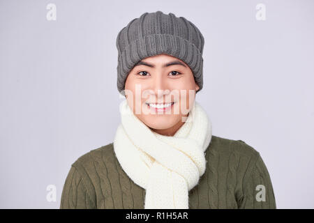 Schönen winter asiatischer Mann auf gestrickte wollene Kleidung Hut Stockfoto