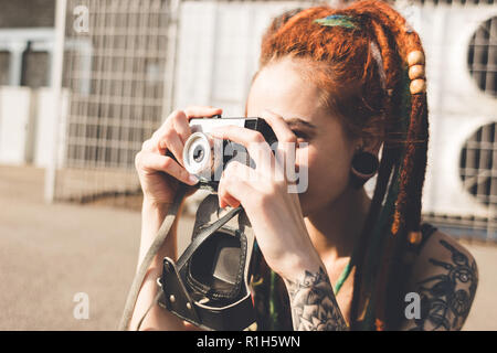 Junges Mädchen mit Tattoo und dreadlocks Bilder auf städtischen industriellen Hintergrund geschieht. Stockfoto