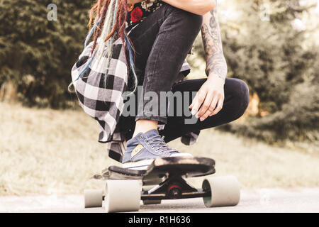 In der Nähe der Beine und Longboard stehen auf Asphalt. Stockfoto