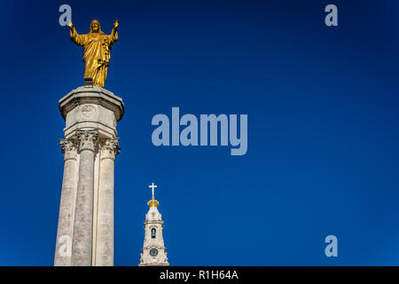 Fátima ist das Zentrum der katholischen Religion in Portugal. Die Statue von Jesus steigt hoch in den wichtigsten Platz der Basilika. Stockfoto