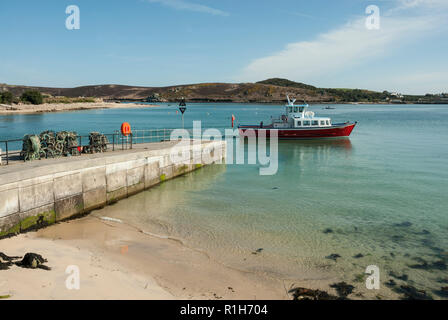 Eine Fähre, die Kirche Quay Jetty, Bryher, an einem schönen sonnigen Tag, blauer Himmel und Meer und goldenem Sand. Isles of Scilly. Stockfoto