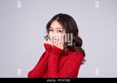 Portrait of Beauty Winter asiatische Mädchen im roten Kleid aus Wolle gestrickt. Weihnachtsfeiertag. Stockfoto