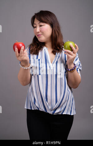 Reifen schöne asiatische Geschäftsfrau mit Apfel Obst Stockfoto