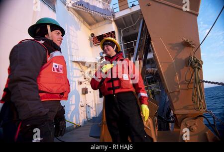 ARCTIC OCEAN - U.S. Merchant Marine Academy Cadet Taylor Crisci (links) und der U.S. Coast Guard Petty Officer 2nd class Shannon Eubanks sprechen nach der Bereitstellung einer Reihe von Sensoren in das Chukchi Meer von der U.S. Coast Guard Cutter Healy (WAGB-20) Mittwoch, September 19, 2018, etwa 100 Meilen nordwestlich von Barrow, Alaska. Wenn Klassen sind nicht in der Sitzung, MMA Kadetten verbringen ihren Sommer an Bord der operativen Einheiten - auf See - Erfahrungen zu sammeln, bevor sie graduieren. Etwa 30 Wissenschaftler an Bord der Healy Bereitstellung von Sensoren und autonome U-Boote in der Arktis geschichteten Ocean dynamics zu studieren Stockfoto