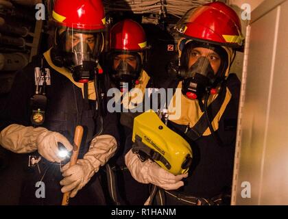 Golf von Aden (Sept. 19, 2018) Matrosen zu San Antonio zugeordnet - Klasse amphibious Transport dock Schiff USS Anchorage LPD (23) in einem General Quarters bohren teilnehmen, während einer planmäßigen Einsatz von Essex Amphibious Ready Group (ARG) und dem 13 Marine Expeditionary Unit (MEU). Das Essex ARG/13 MEU ist eine tödliche, flexibel, und anhaltende Navy-Marine Corps Team in die USA 5 Flotte Bereich der Maßnahmen zur Unterstützung der Marine im Einsatz für die Stabilität und Sicherheit in der Region zu gewährleisten und verbindet das Mittelmeer und den Pazifischen Raum durch den westlichen Indischen Ozean und Stockfoto