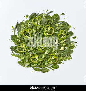 Verschiedene grünes Gemüse Brokkoli, Spinat, Rosenkohl, Spargel, Minze, Gurke und Paprika Schichten auf einem grauen Hintergrund mit Platz für Text. Gesunde Ernährung Konzept. Flach Stockfoto