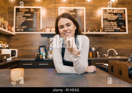 Portrait von lächelnden jungen weiblichen Coffee shop besitzer, selbstbewusste Frau, die an der Theke. Stockfoto