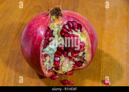Granatapfel auf einer hölzernen Hintergrund geöffnet. Close Up. Stockfoto